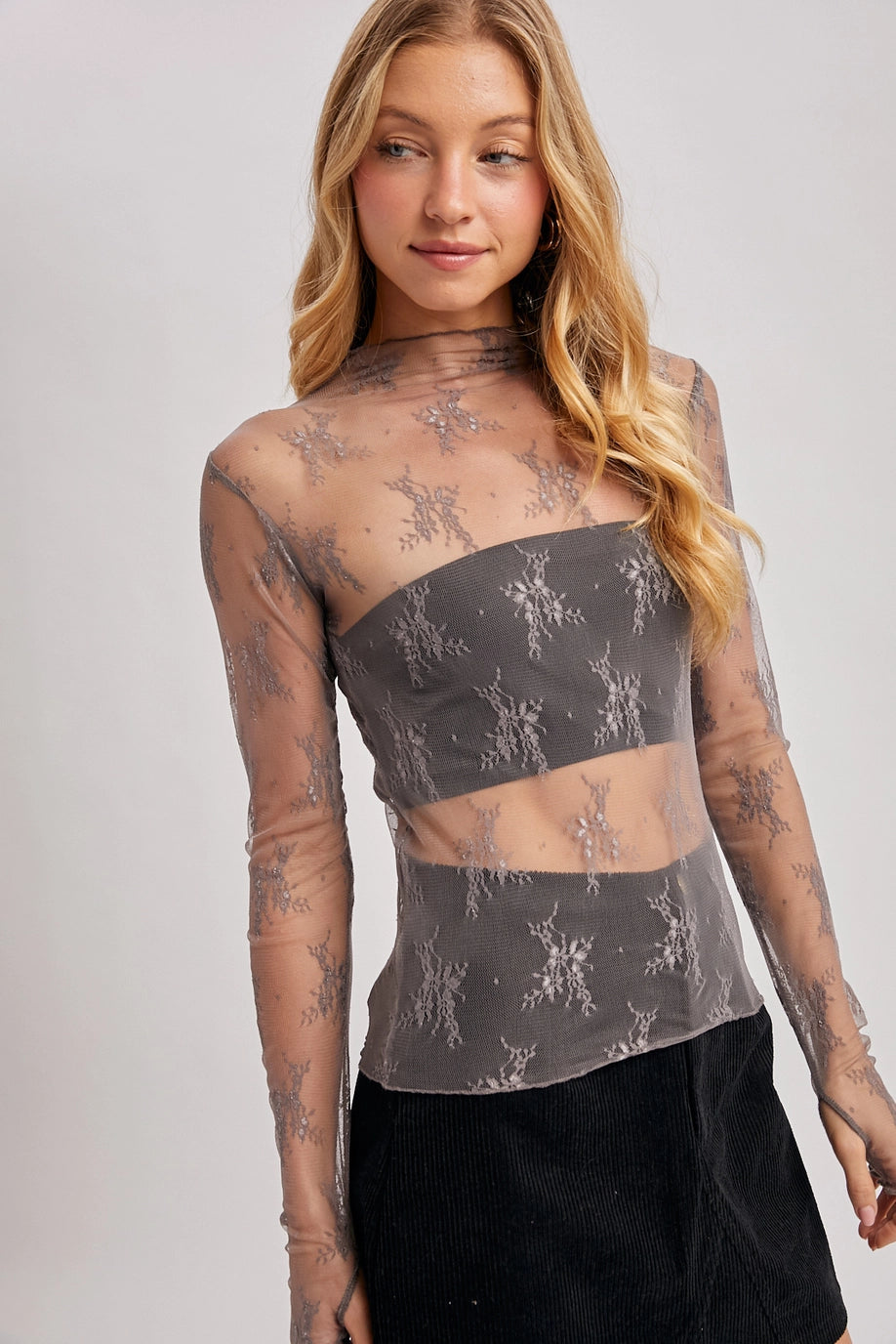 Woman wearing a mesh top with floral patterns in mauve hue